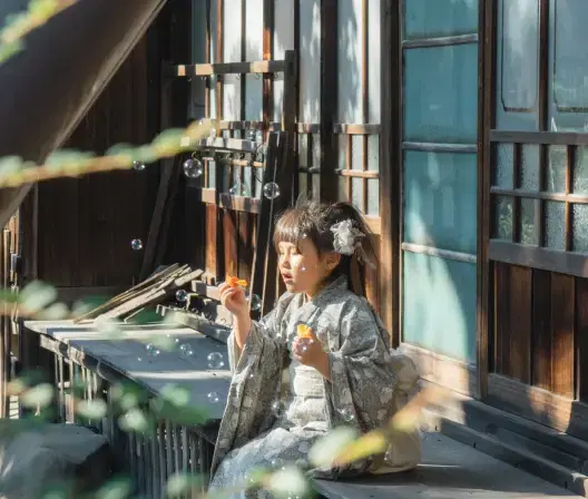 女の子が境内の縁側に座っている
