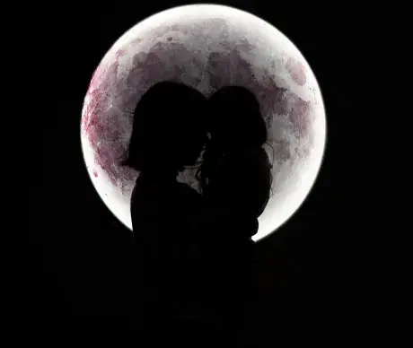満月を背景に親子がシルエットで写っている