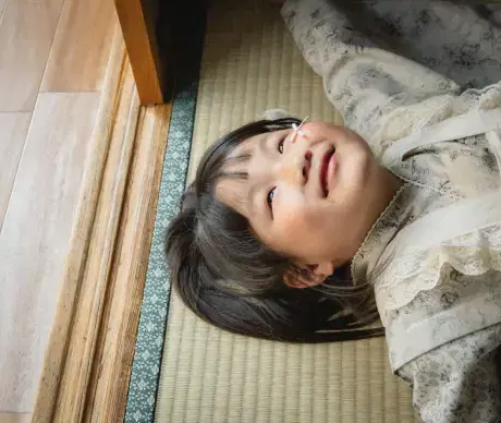 子供が畳の上で気持ちよさそうに寝そべっている